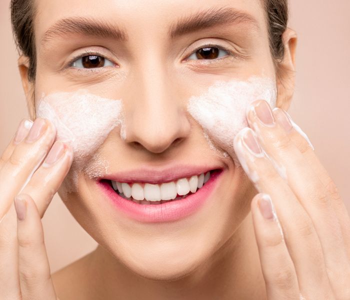 Woman with soap lather on face, soft skin